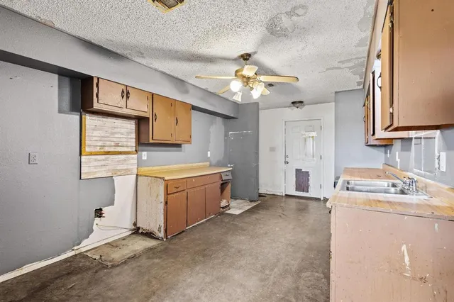 a kitchen with stainless steel appliances granite countertop a sink a stove a refrigerator cabinets and wooden floor