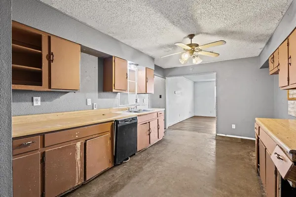 a kitchen with a sink a stove and cabinets