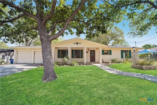 a front view of a house with a garden and yard