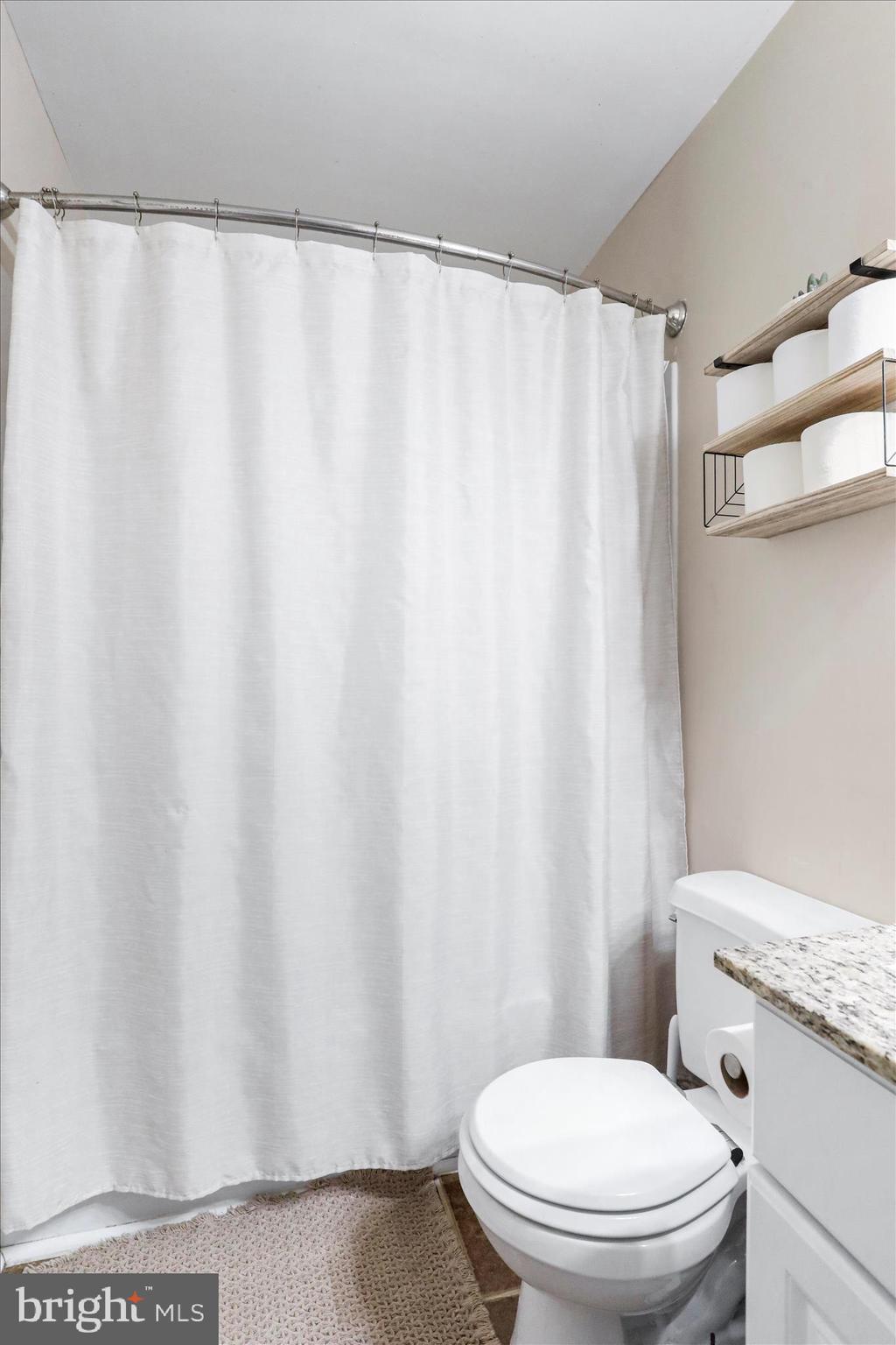 4402 Shatzer Street Chambersburg, PA 17202 - Photo 19 of 30 a white toilet sitting next to a shower curtain