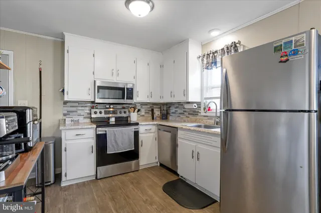 a kitchen with white cabinets and white appliances