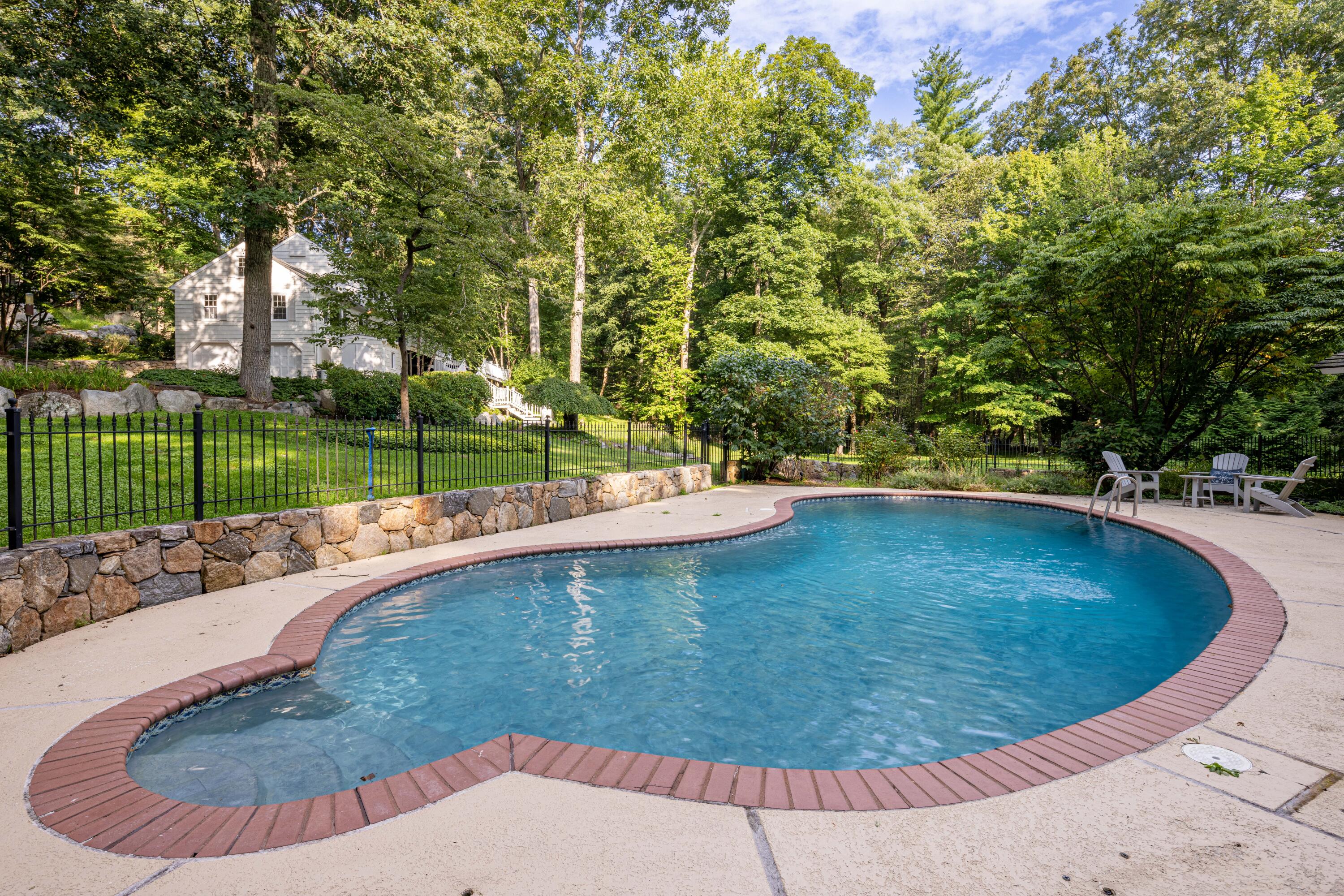 69 Mariomi Road New Canaan, CT 06840 - Photo 4 of 30 a view of a swimming pool with a patio