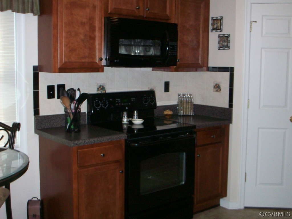 15813 Sandwave Road Chester, VA 23831 - Photo 7 of 24 a kitchen with granite countertop a stove and a microwave