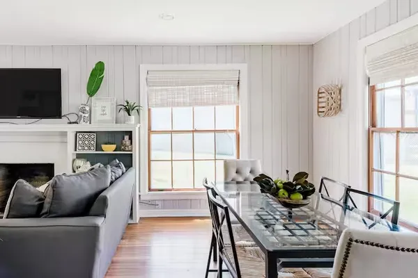 a living room with furniture a fireplace a flat screen tv and a window