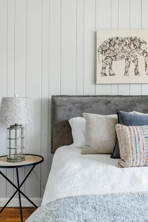a bed sitting in a bedroom and table chair