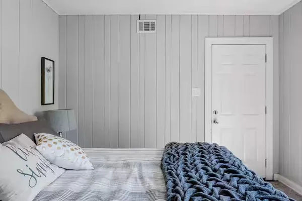 a view of a bedroom with wooden floor and bathroom