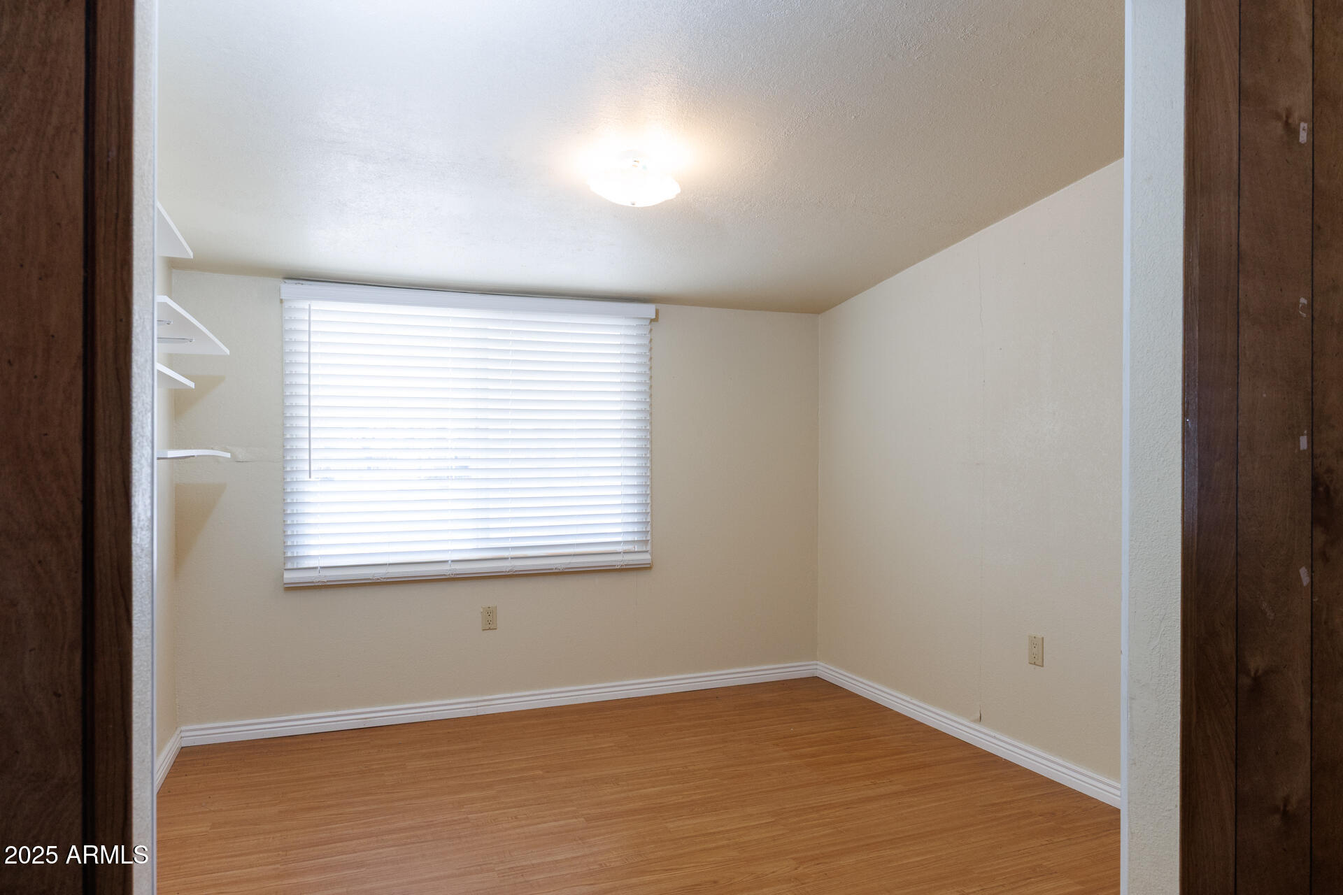 2100 North Trekell Road, Unit 144 Casa Grande, AZ 85122 - Photo 24 of 36 a view of an empty room with wooden floor and a window