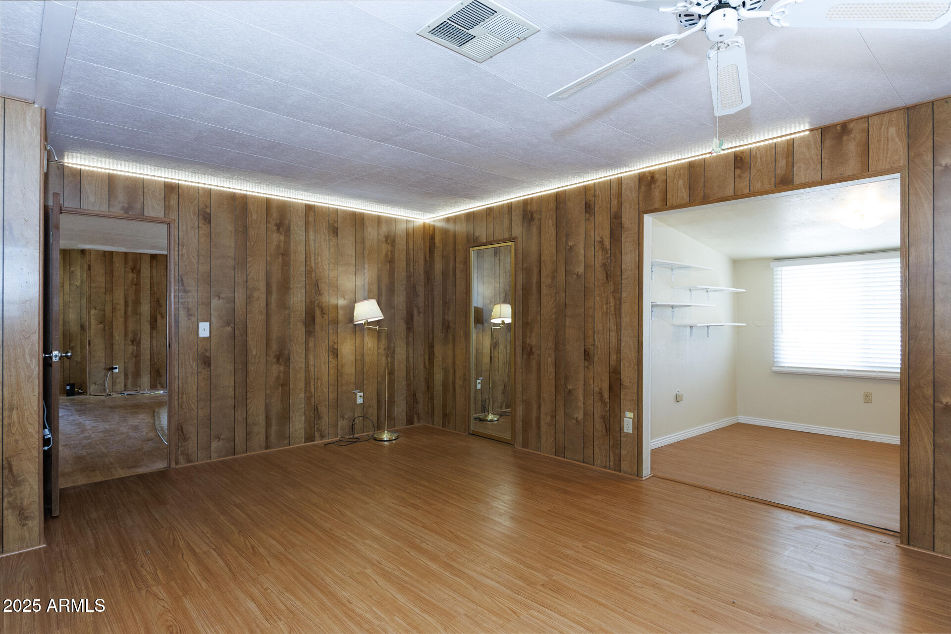 2100 North Trekell Road, Unit 144 Casa Grande, AZ 85122 - Photo 25 of 36 an empty room with wooden floor and way to kitchen
