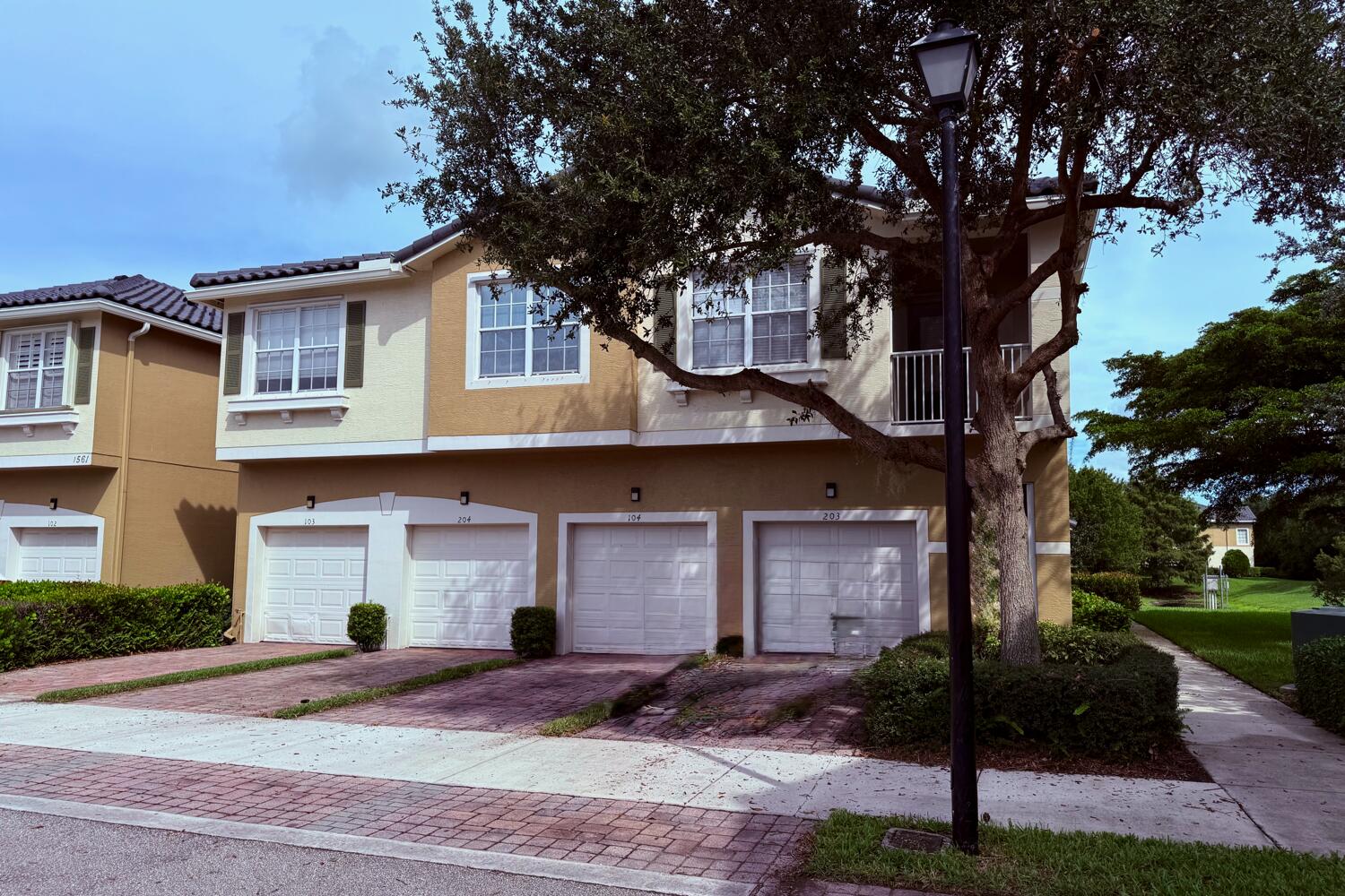 1561 Southeast Hampshire Way, Unit 104 Stuart, FL 34994 - Photo 1 of 23 a front view of a house with garden and trees