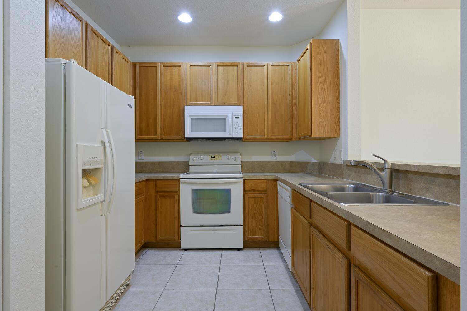 1561 Southeast Hampshire Way, Unit 104 Stuart, FL 34994 - Photo 11 of 23 a kitchen with a refrigerator sink and stove