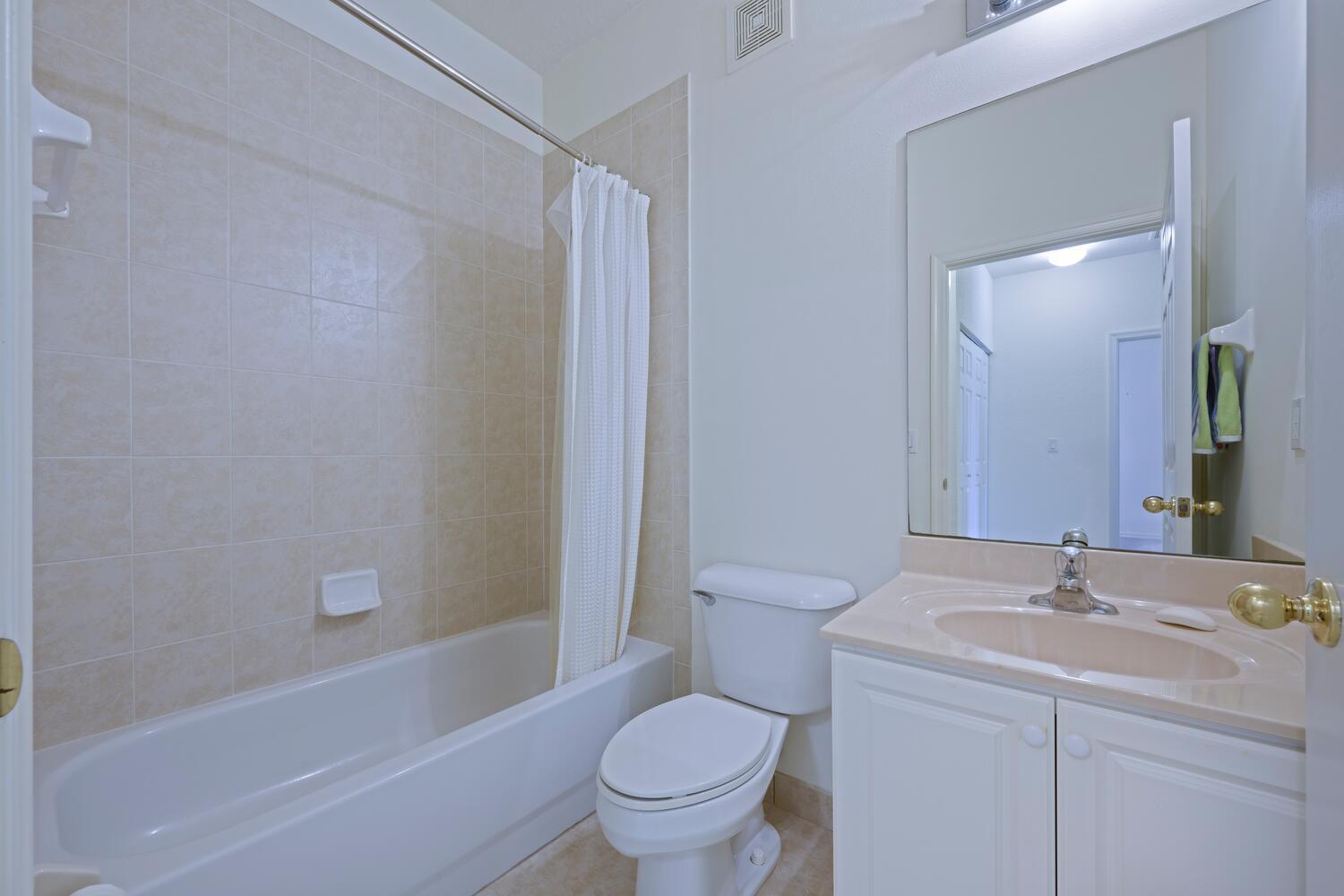 1561 Southeast Hampshire Way, Unit 104 Stuart, FL 34994 - Photo 15 of 23 a bathroom with a sink toilet and shower