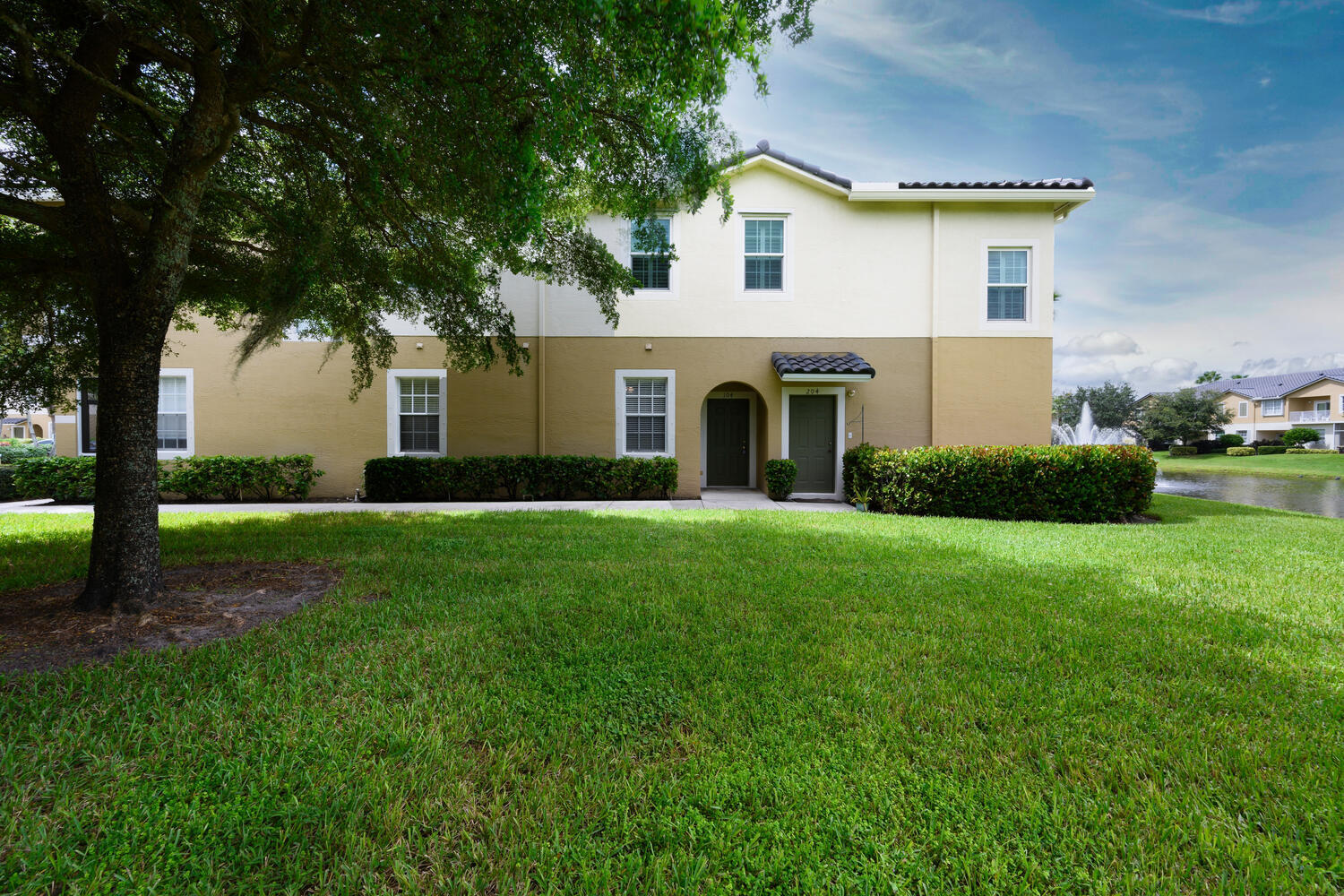1561 Southeast Hampshire Way, Unit 104 Stuart, FL 34994 - Photo 2 of 23 a front view of a house with a garden