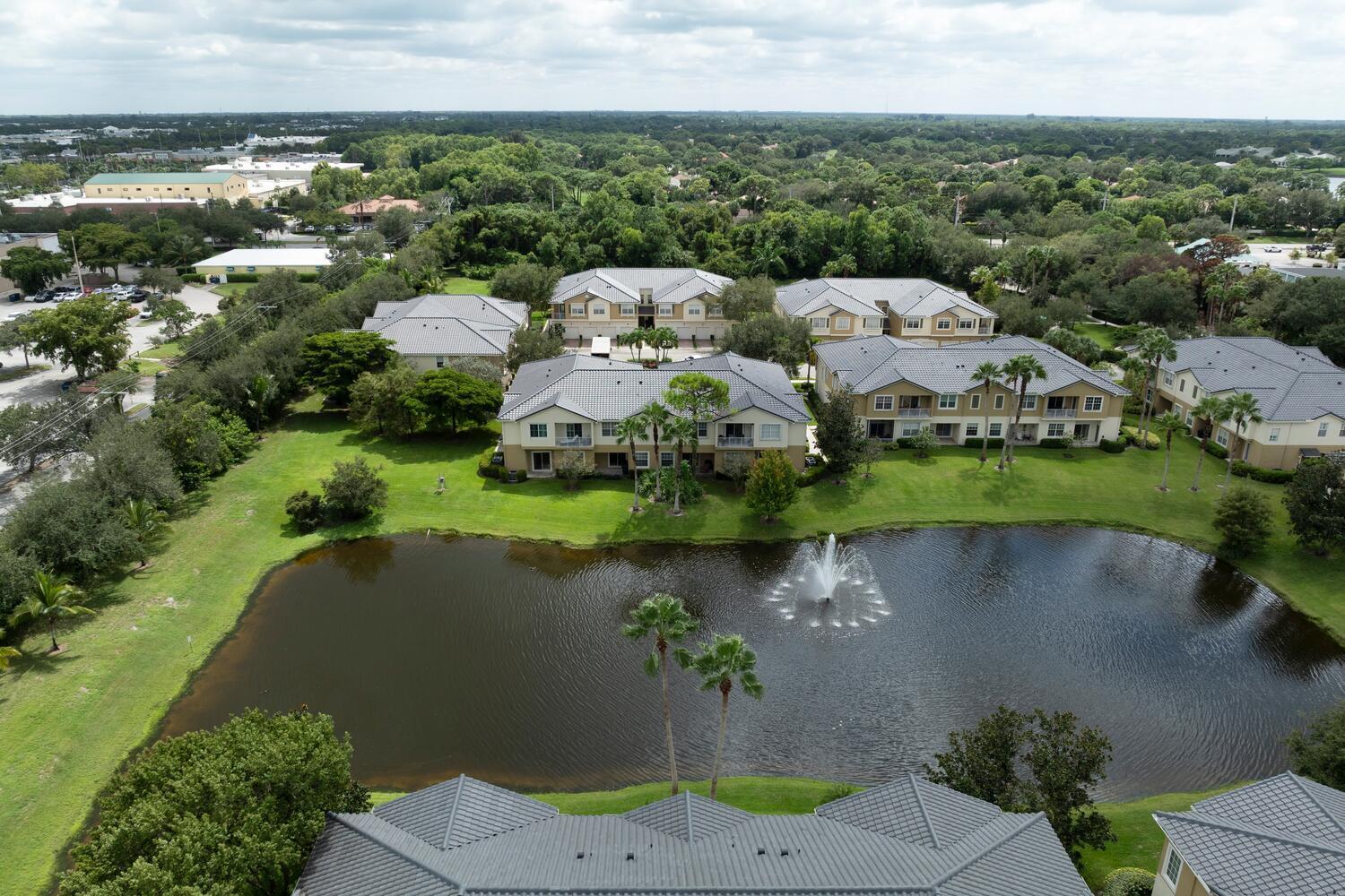 1561 Southeast Hampshire Way, Unit 104 Stuart, FL 34994 - Photo 21 of 23 an aerial view of a house with a yard and lake view