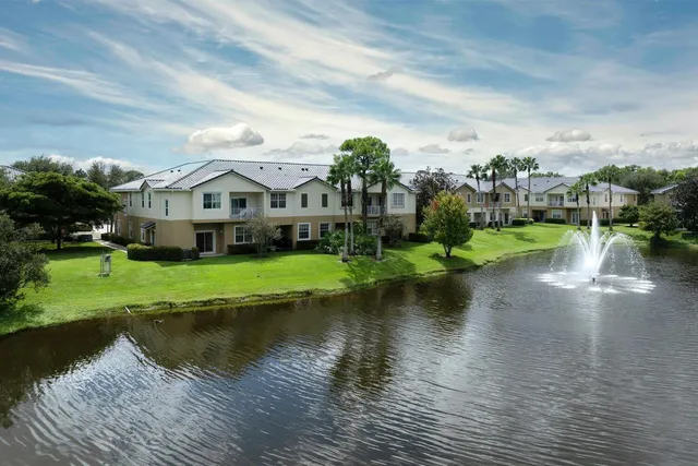 a view of a house with a yard and lake view