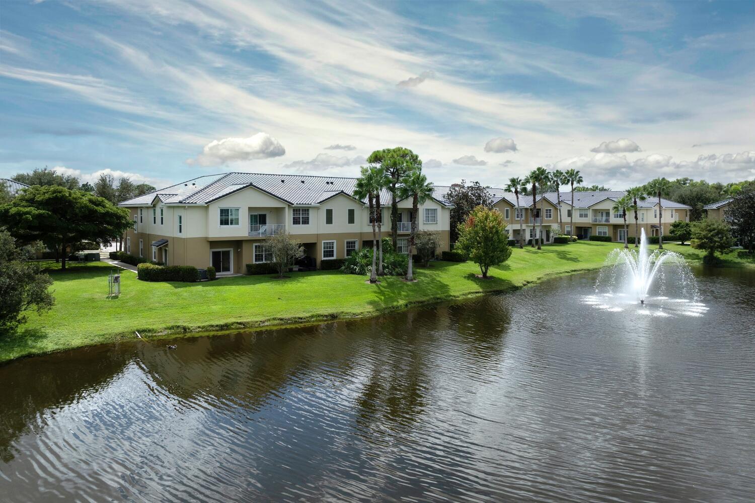 1561 Southeast Hampshire Way, Unit 104 Stuart, FL 34994 - Photo 3 of 23 a view of a house with a yard and lake view