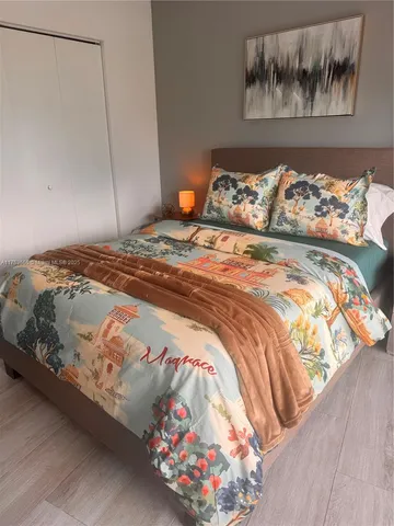a bedroom with a bed and a painting on the wall