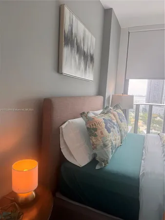 a bed sitting in a bedroom next to a window