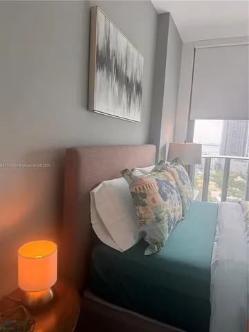 a bedroom with a bed and painting on the wall