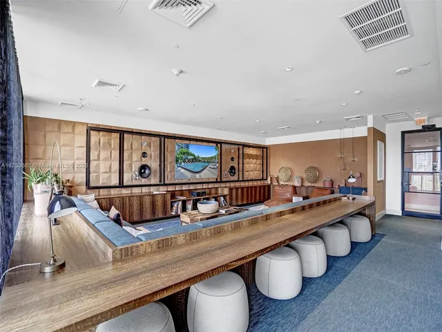 a living room with blue lights with furniture and a potted plant