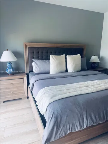 a large bed sitting in a bedroom next to a lamp and a lamp