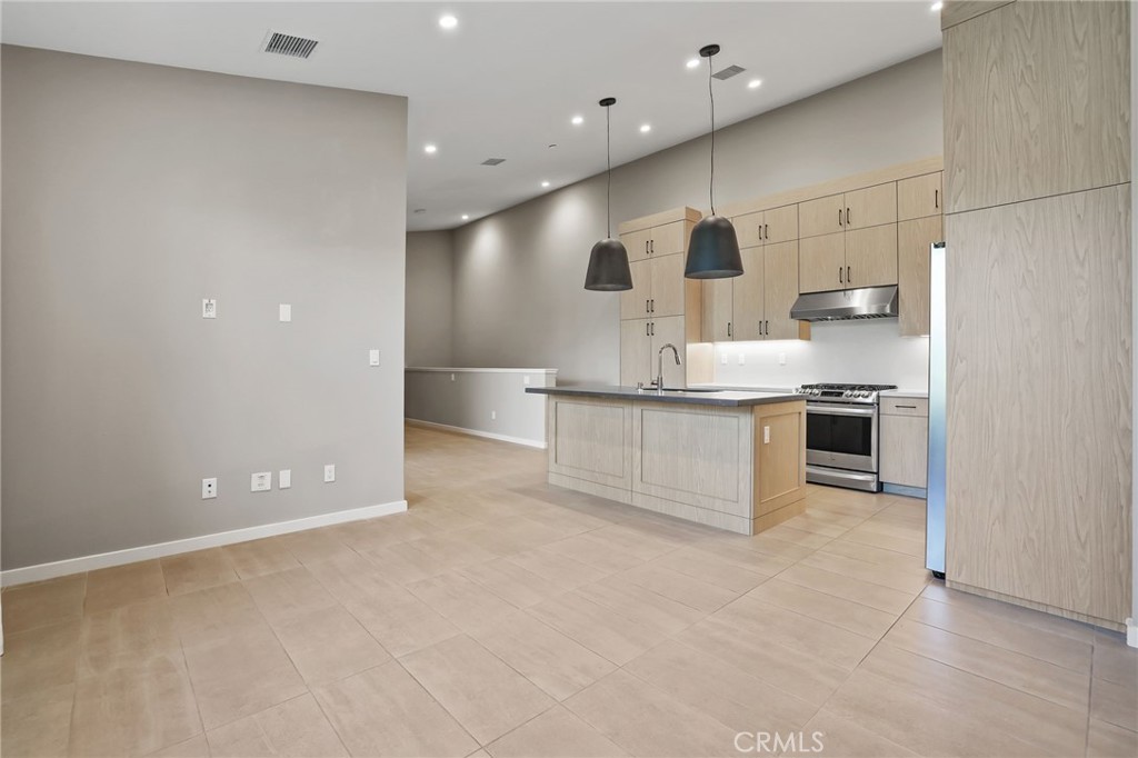 110 Coastal Garden Irvine, CA 92618 - Photo 15 of 33 a kitchen with stainless steel appliances granite countertop a refrigerator and a sink