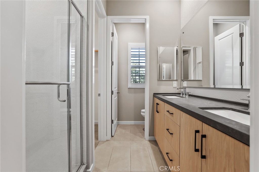 110 Coastal Garden Irvine, CA 92618 - Photo 21 of 33 a spacious bathroom with a granite countertop sink and a mirror