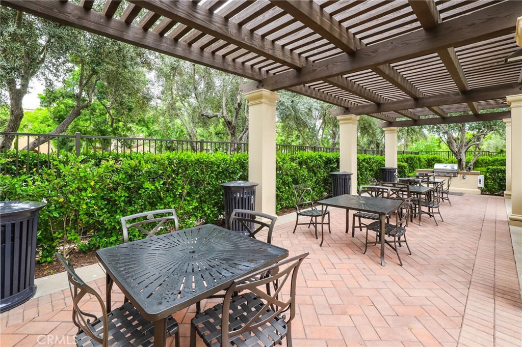 110 Coastal Garden Irvine, CA 92618 - Photo 30 of 33 a view of a patio with a table and chairs under an umbrella with a barbeque
