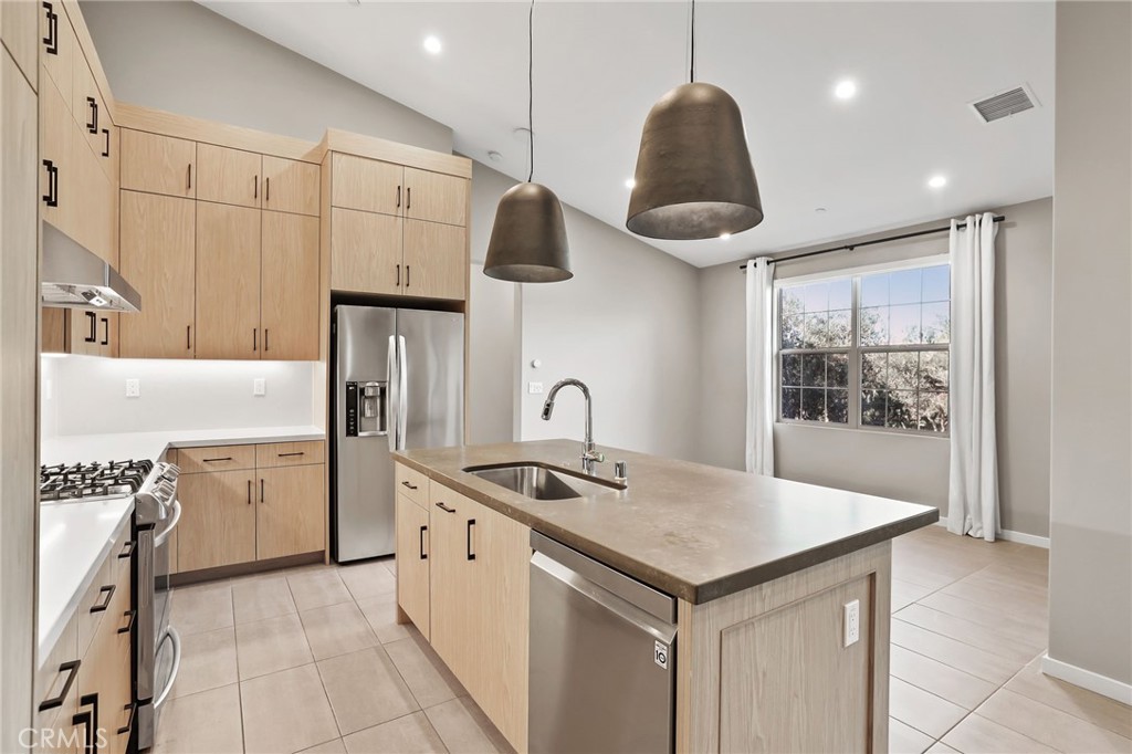 110 Coastal Garden Irvine, CA 92618 - Photo 9 of 33 a kitchen with stainless steel appliances granite countertop a sink a oven and a refrigerator with wooden floor