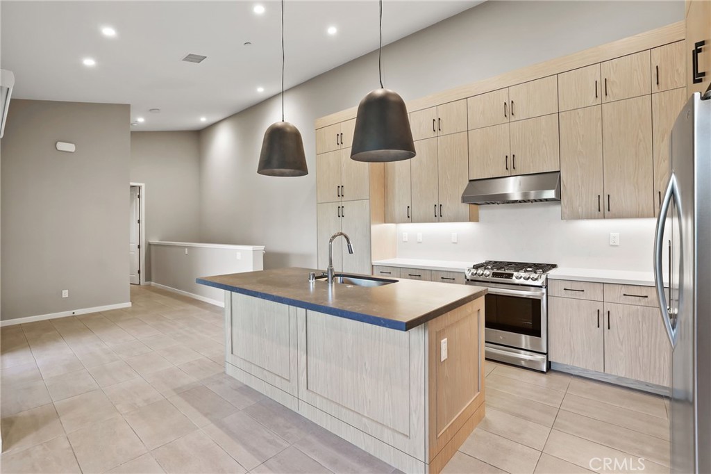 110 Coastal Garden Irvine, CA 92618 - Photo 10 of 33 a kitchen with stainless steel appliances granite countertop a sink a stove and a refrigerator