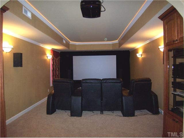 1805 Wescott Drive Raleigh, NC 27614 - Photo 10 of 12 Spacious Media Rm features 110" screen, custom lighting & curtains, wall sconces, tray ceil, crown molding, DVD cabinet, Media cabinet & Kitchenette w/bar sink, bar fridge & MW. Media Room