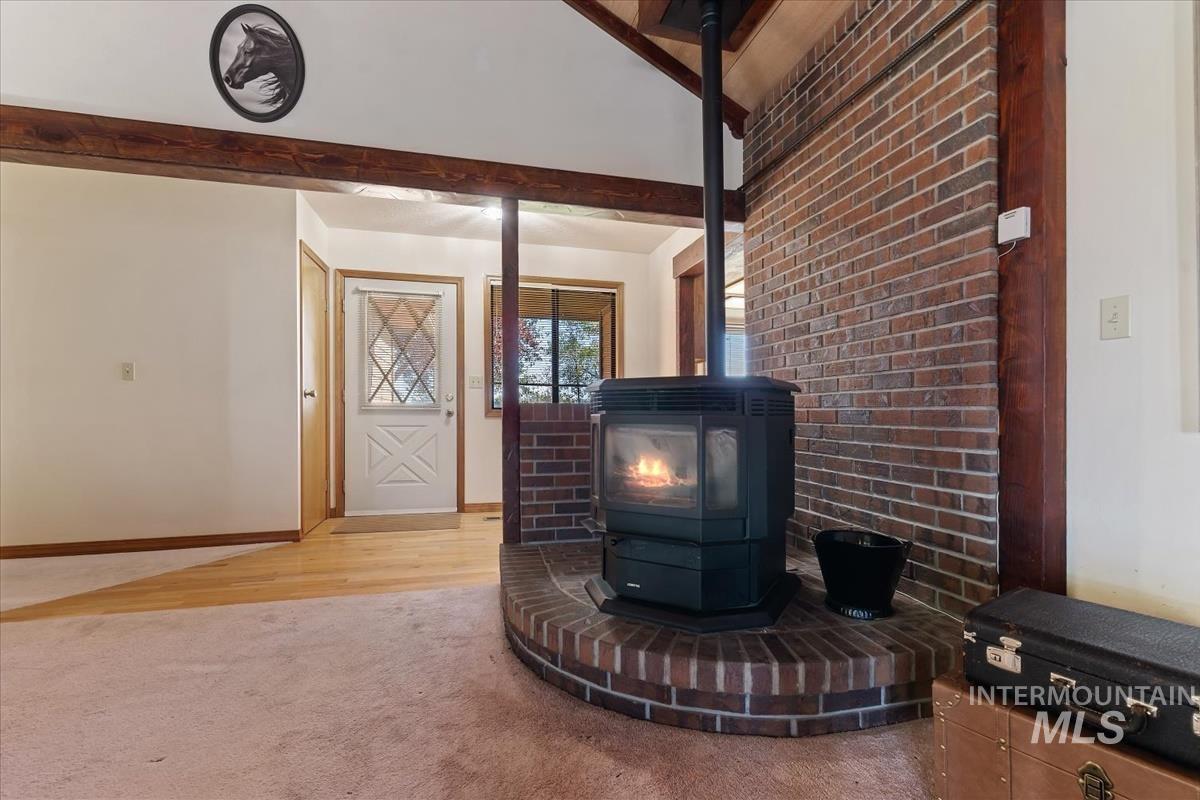 8275 Washoe Road Fruitland, ID 83619 - Photo 6 of 43 Wood-burning stove with a brick hearth and exposed brick wall