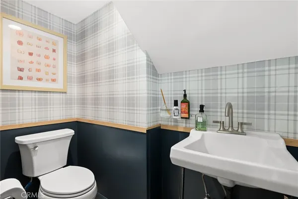 a bathroom with a sink a toilet and mirror