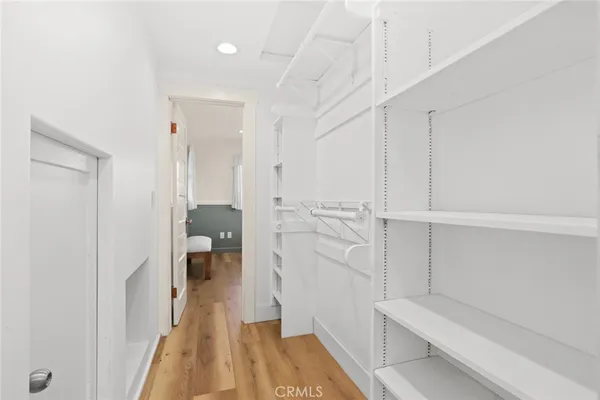 a hallway with white cabinets and wooden floor