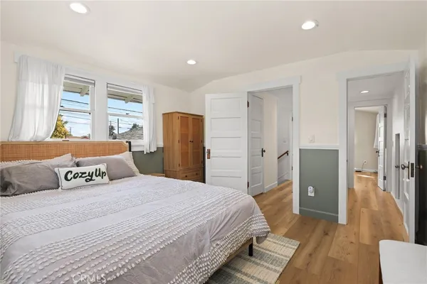 a bedroom with a large bed and wooden floor