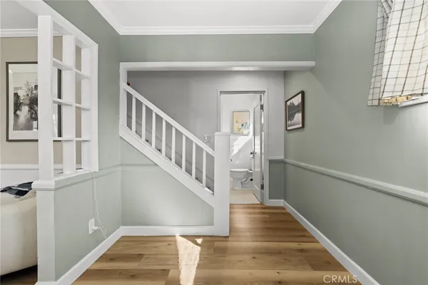 a view of staircase with lots of frames on wall and a window