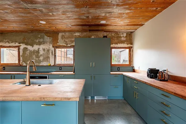 a kitchen with granite countertop a table chairs sink and wooden floor