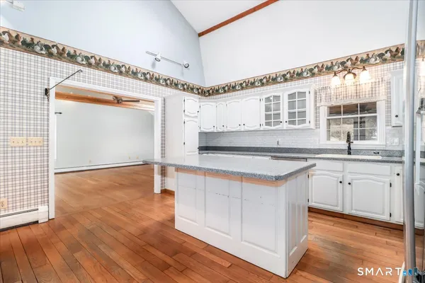 a kitchen with stainless steel appliances granite countertop a sink and a wooden floors