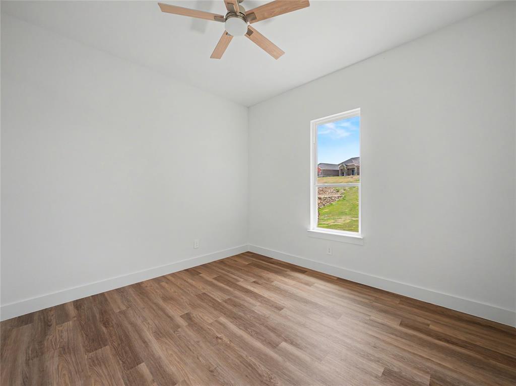 328 Slimp Bluff Azle, TX 76020 - Photo 23 of 30 Room featuring wood-finish flooring, a single window, white walls, and a ceiling fan