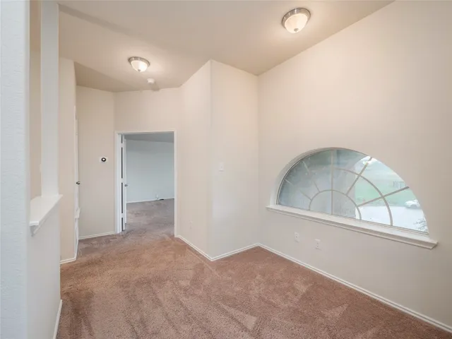 an empty room with a fireplace and windows