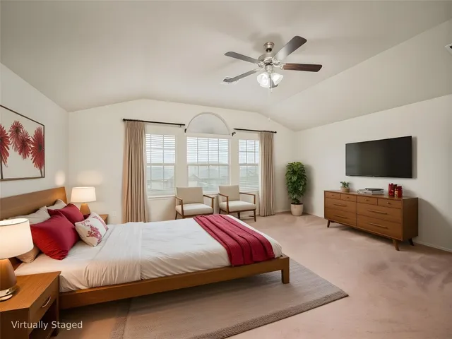 a spacious bedroom with a bed and a flat screen tv