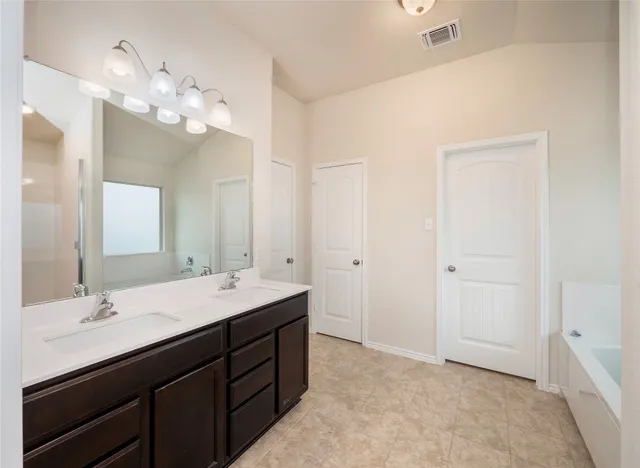 a spacious bathroom with a double vanity sink and a mirror