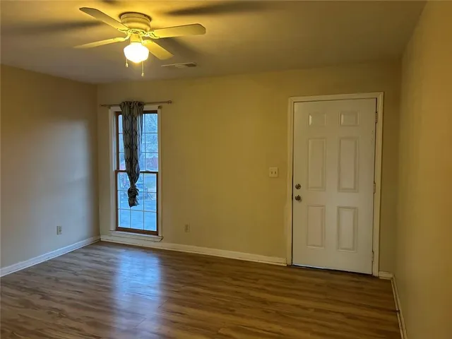 a view of an empty room with wooden floor