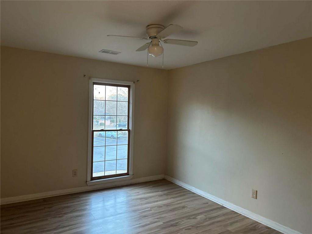 1166 Booth Road Southwest, Unit 709 Marietta, GA 30008 - Photo 10 of 12 an empty room with wooden floor and windows