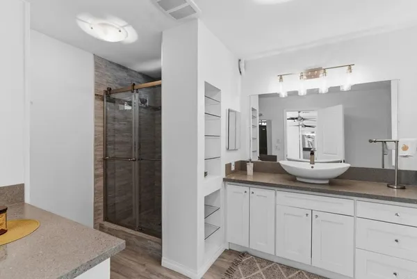 a spacious bathroom with a granite countertop sink and a mirror