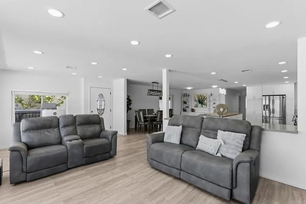 a living room with furniture and a view of kitchen