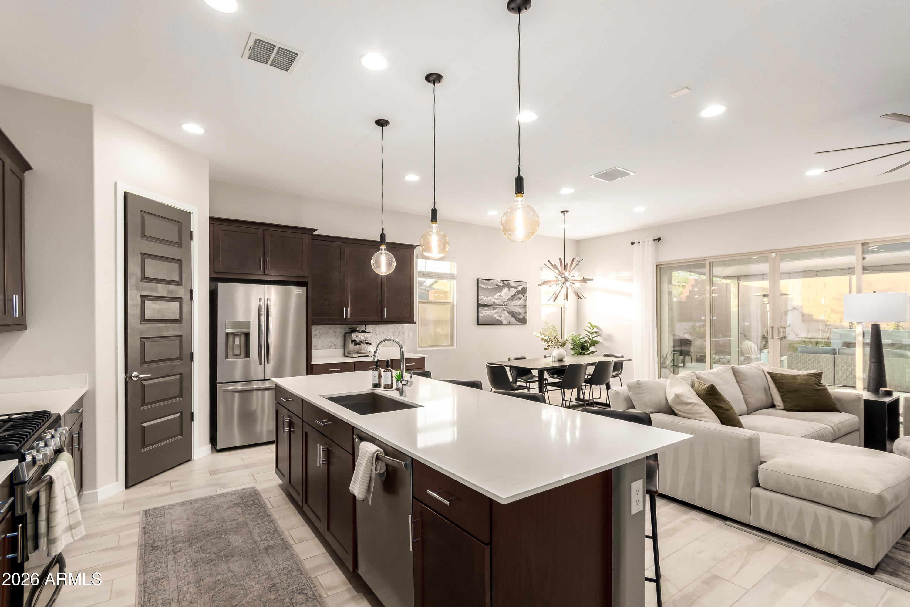 2034 West Sleepy Ranch Road Phoenix, AZ 85085 - Photo 6 of 35 a open kitchen with stainless steel appliances kitchen island a large counter top a sink a stove and a refrigerator