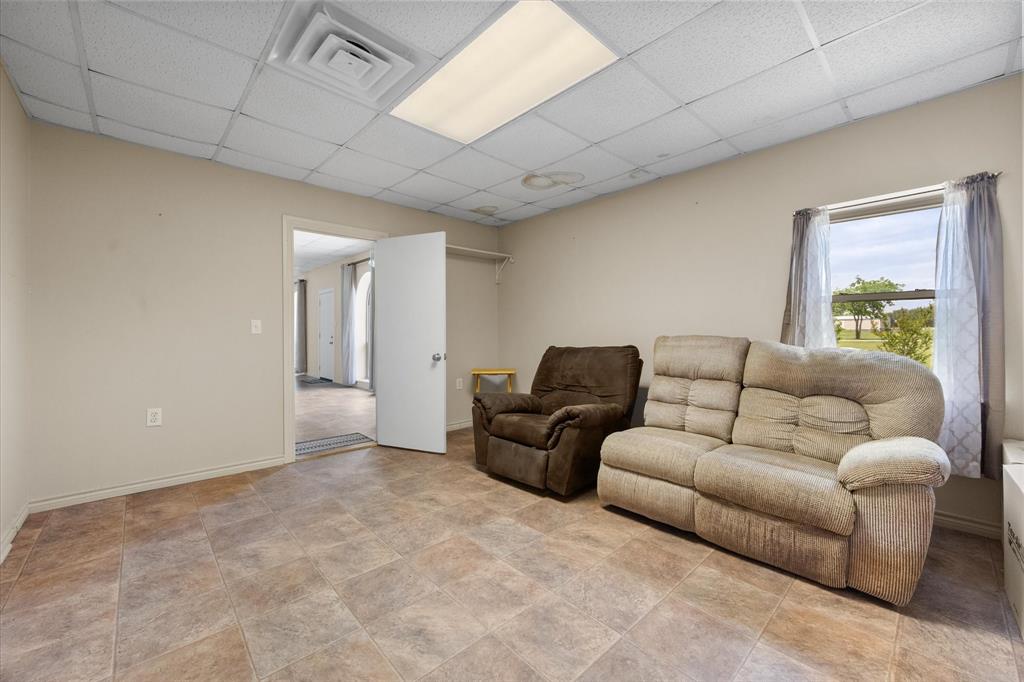 2101 Ridge View Drive Cleburne, TX 76033 - Photo 11 of 31 Interior room featuring neutral wall paint, tiled flooring, a drop ceiling with recessed lighting, and a window with natural light
