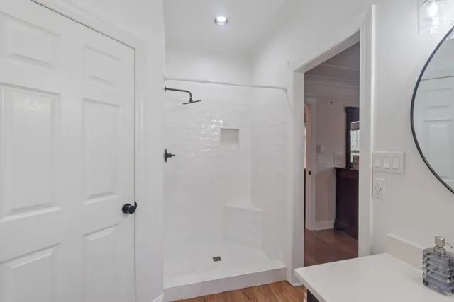 a spacious bathroom with a tub sink and mirror