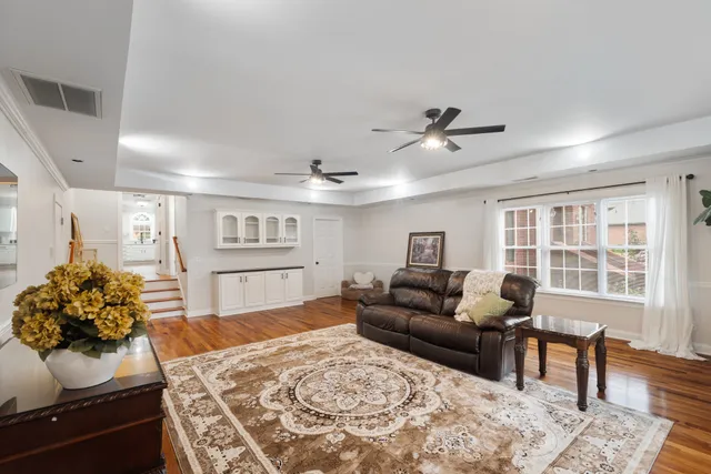 a living room with furniture and a wooden floor