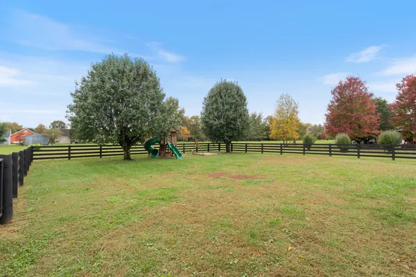 an aerial view of a house with a garden and lake view